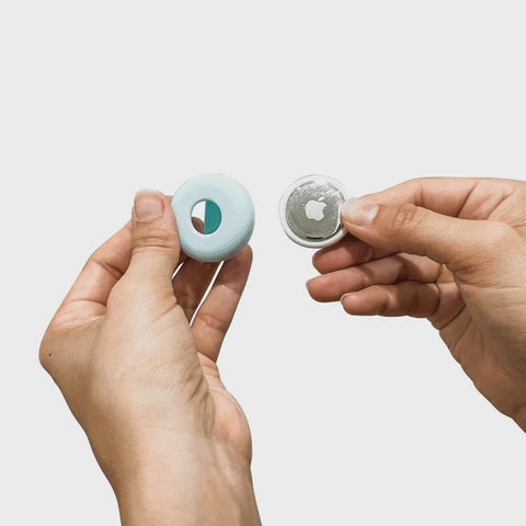 Stopmotion how-to-use gif of 2 hands inserting Apple AirTag into slate blue fetch airtag holder for use on your dogs collar or dogs harness.