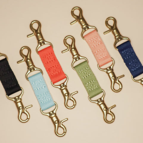 Awoo dog saftey strap with double brass clip ends. Shown in Olive green, Peach pink, Spice red, Navy blue, Slate light blue, and black. The safety clip can be attached to the dog harness, collar or/and leash for added security with your dog.
