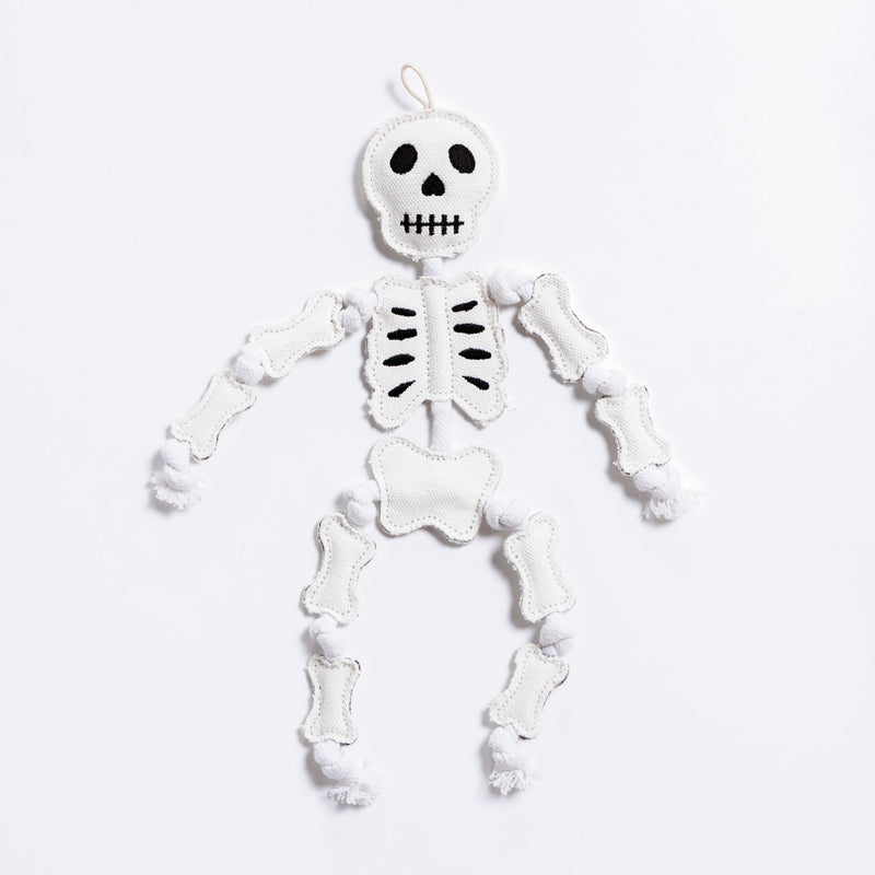 A durable white cotton canvas skeleton with cotton rope dog toy with black embroidered facial features and black rib details, shown against a plain white background.