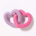 Two heart-shaped felt dog toys, one pink and one purple, interlinked on a white background.
